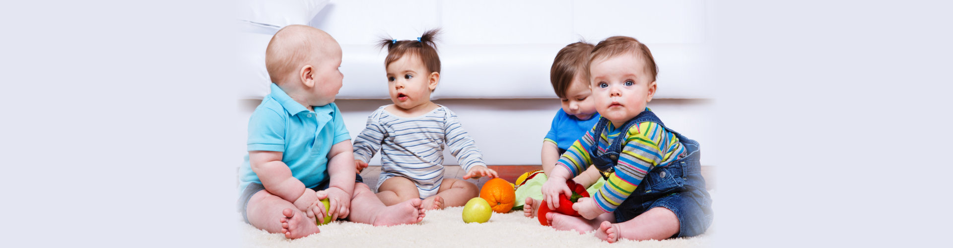 four babies group sitting on the floor